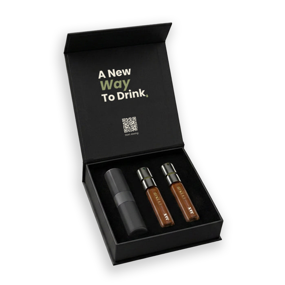 An open black gift box on a white background containing three small cylindrical elixir bottles and JAX case. The inside lid has printed text reading 'A New Way To Drink.